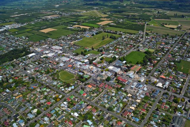 Aerial view of Motueka town centre with orchards and farmland beyond.