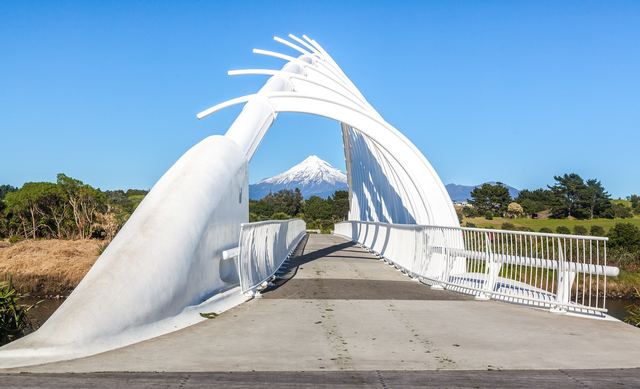 The white Te Rewa Rewa Bridge in New Plymouth framing snow-capped Mount Taranaki.
