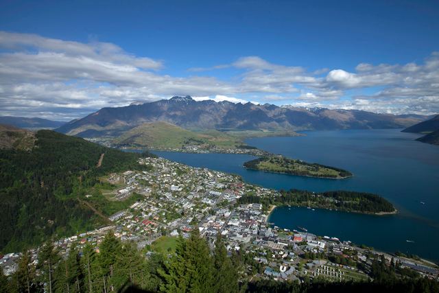 Aerial view of Queenstown on the shore of Lake Wakatipu with mountains behind.